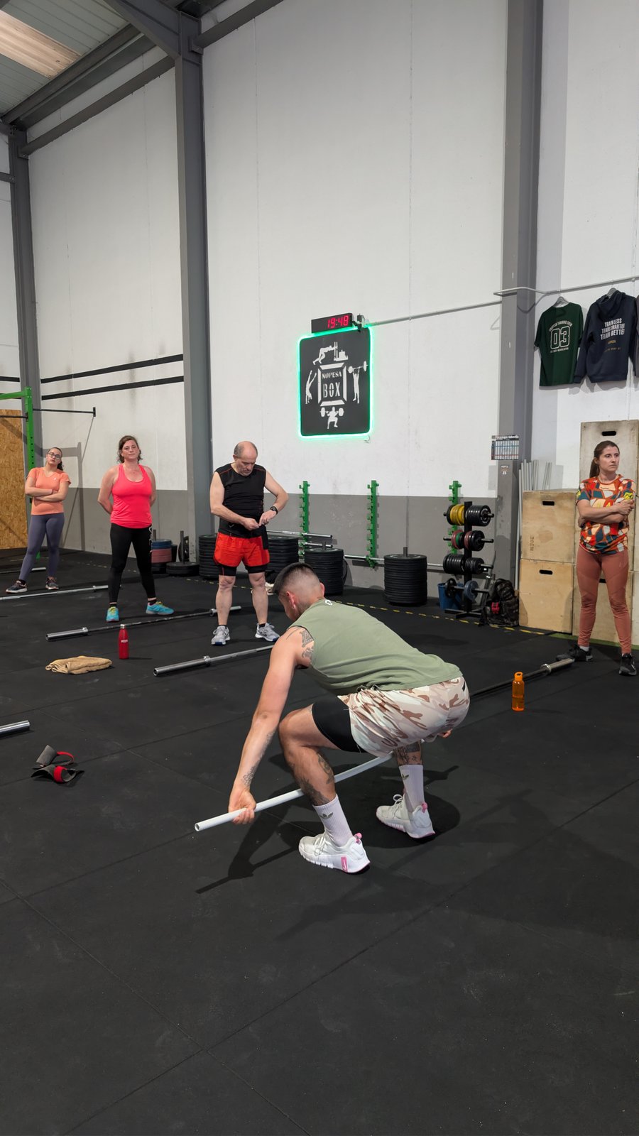 Coach corrigiendo técnica de levantamiento